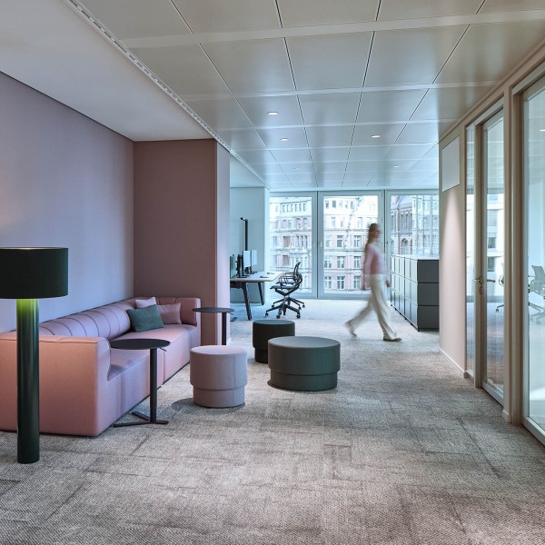 Loungebereich mit rosa Sofa und Poufs im Büro des Hanseatic Energy Hub in Hamburg
