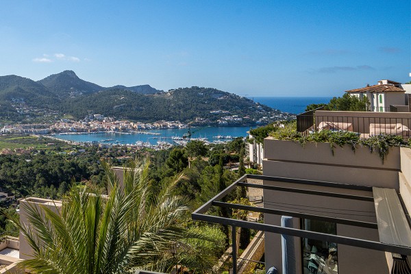 Der Ausblick von der Terrasse eines modernen Appartements auf Mallorca. Der Panoramablick reicht über grüne Hügel, Palmen und die Hafeneinfahrt von Port d’Andratx bis hin zum offenen Meer.