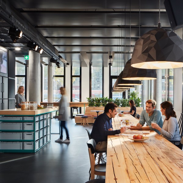 Sobremesa bei Havas Berlin mit langen Holztischen und großen Lampen