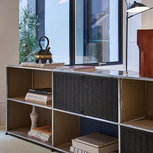 Beiges USM Sideboard mit schwarzen Soft Panels und Deko.