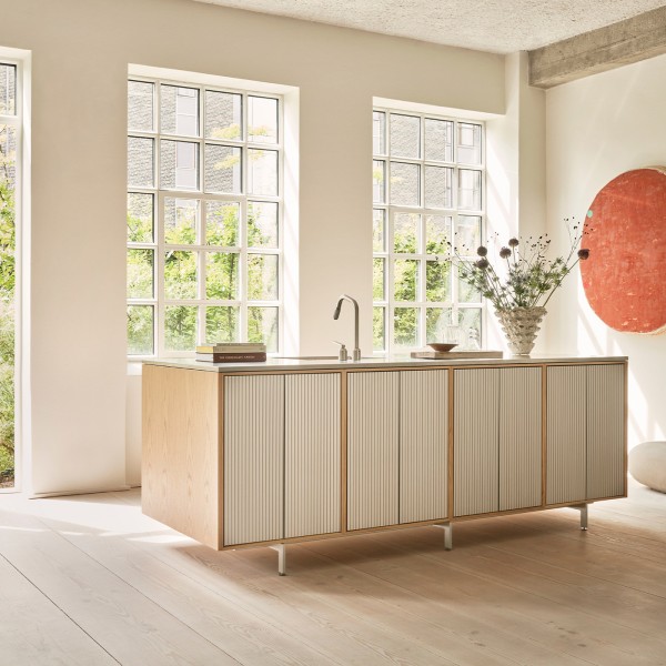 Vipp V2 Kücheninsel aus hellem Eichenholz in lichtdurchflutetem Raum.