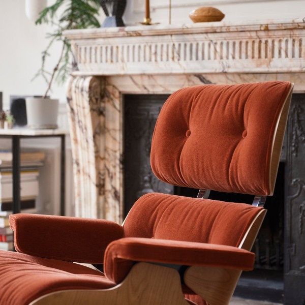 Eames Lounge Chair mit Ottoman in Stoff Calma in modernem Wohnraum mit Kamin.